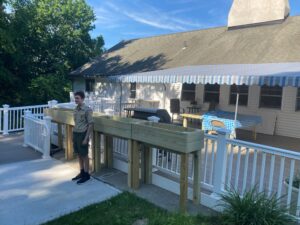 Eagle Scout Ben stands in front of planters he built
